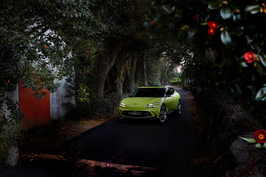 a green car driving down a dark street