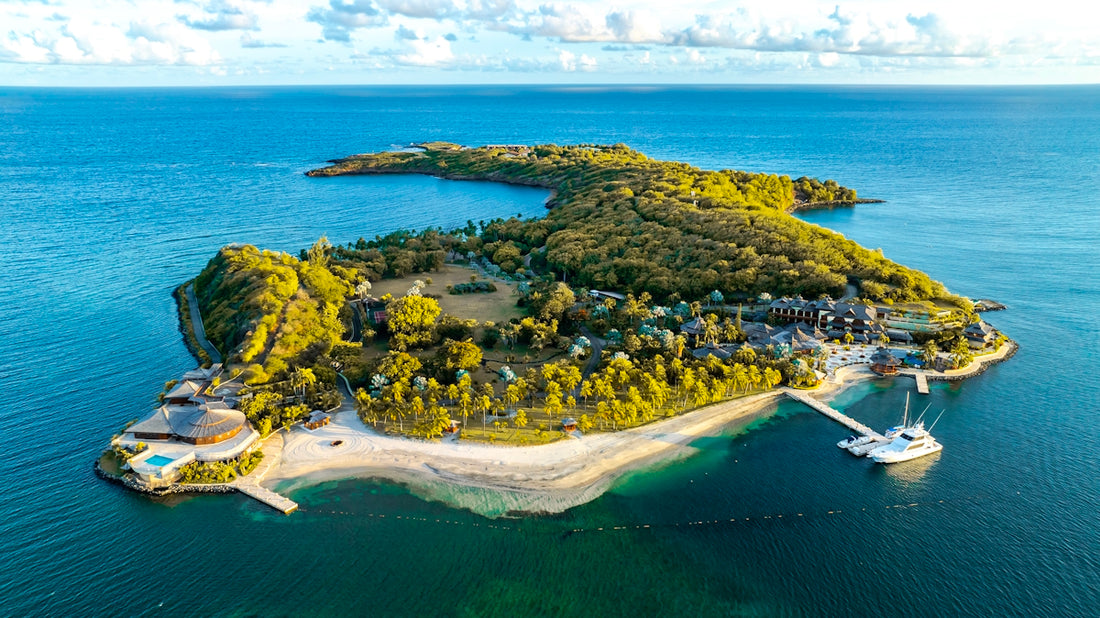 Lush green island resort surrounded by clear blue ocean water.