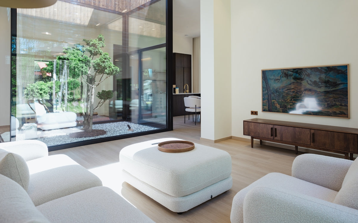 Modern living room with courtyard view and television.