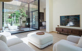 Modern living room with courtyard view and television.