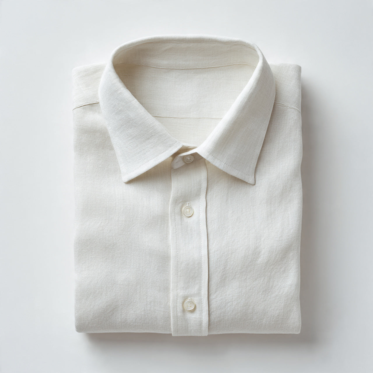 “A folded linen shirt or linen pants centered on a pure white seamless background. Straight-on studio shot with soft natural lighting and a subtle shadow. No text, no logo, no model, no props.”