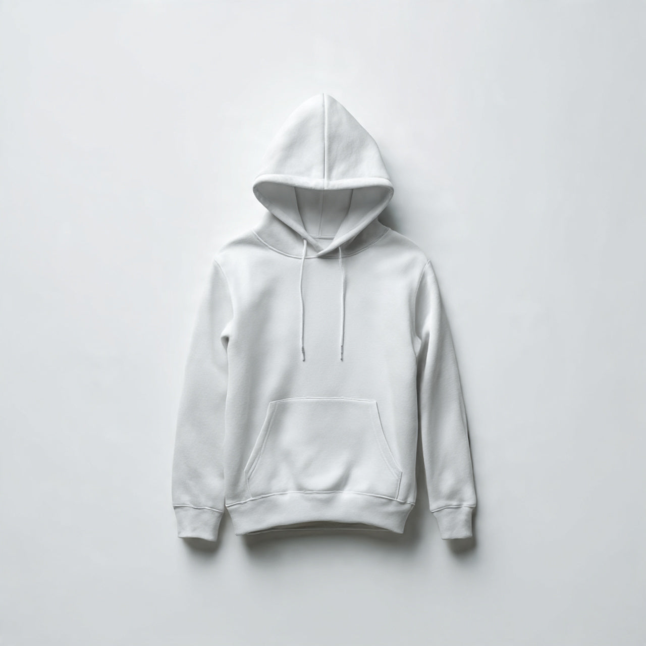 “A folded women’s hoodie centered on a pure white seamless background. Straight-on studio photography with soft lighting and a subtle shadow. No text, no logo, no model, no props.”