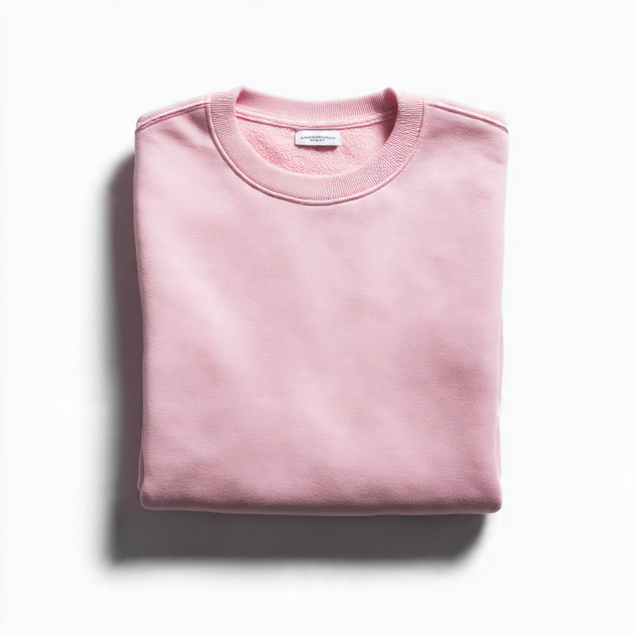 “A folded women’s T-shirt centered on a pure white seamless background. Straight-on high-end product photography with soft lighting and minimal shadow. No text, no logo, no model, no props.”