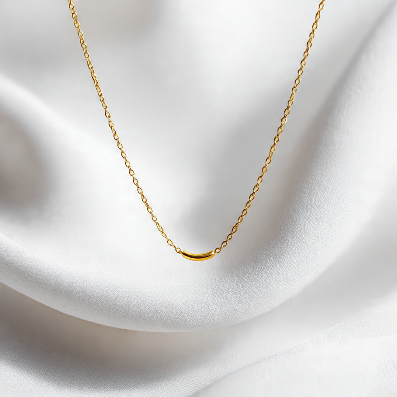 “A single gold or silver necklace centered on a pure white seamless background. Straight-on luxury jewelry shot with soft lighting and a delicate shadow. No text, no logo, no model, no props.”