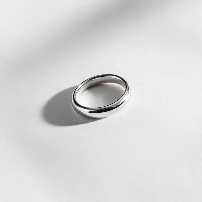 “A single minimalist ring centered on a pure white seamless background. Straight-on jewelry product photography with soft diffused lighting and a small shadow. No text, no logo, no model, no props.”
