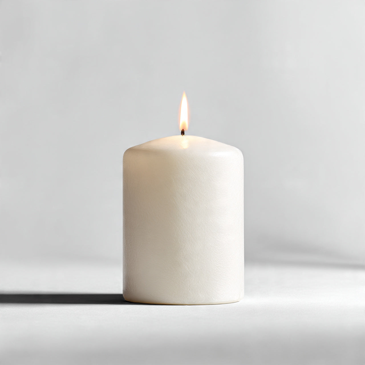 “A single premium candle centered on a pure white seamless background. Straight-on studio shot with soft lighting and a clean shadow. No text, no logo, no model, no props.”